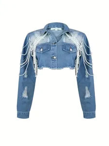 Detail view of cropped blue denim jacket with ripped holes and pearl fringe tassels