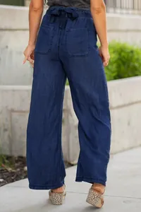 Rear view of lightweight blue wide-leg denim pants featuring a stylish tie-waist detail