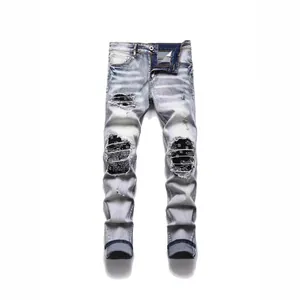 Stylish men's light blue distressed slim fit jeans featuring bandana pattern patchwork details