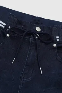 Détail d'un jean élastique pour femme avec cordon de serrage et bande contrastée