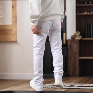 Detailansicht der weißen Slim Fit Herrenjeans mit einzigartigem schwarzen Farbspritzer-Design.