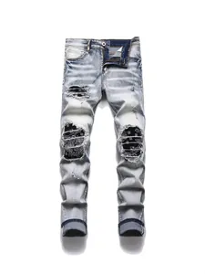 Men's light blue slim-fit distressed jeans with stylish black patterned patches underneath.