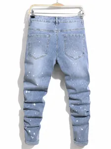 Men's plus size slim fit denim jeans with white paint splatter design in light blue wash.