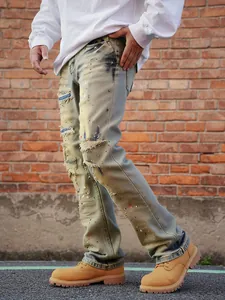 Detailed side view of men's distressed straight leg jeans with vintage rips and splatters
