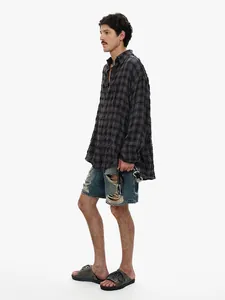 Side view of high-street men's distressed denim shorts with ripped details and raw hem.