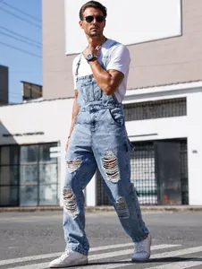 Detailed street style shot of men's ripped denim overalls with adjustable straps