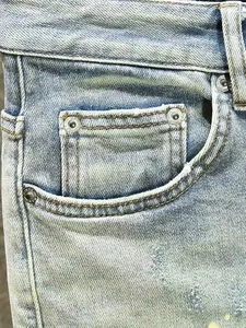 Gros plan d'une poche de jean en denim délavé bleu clair avec rivets métalliques