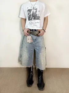 Mannequin portant un short en jean usé avec taches de peinture et ourlet effiloché.