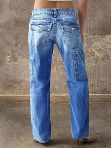 Vaqueros de mujer de pernera ancha y recta estilo high street, vista trasera en fondo industrial