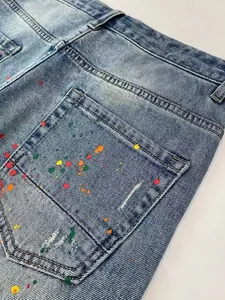 Detail view of men's retro wash denim shorts with colorful paint splatter