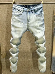 Vue détaillée d'un jean en denim bleu clair vieilli avec une jambe empilée au design unique