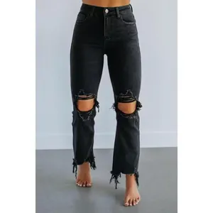 Vue détaillée de face d'un jean noir déchiré à taille haute pour femme avec ourlets effilochés.