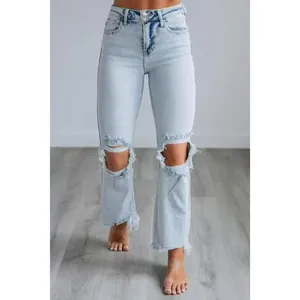 Vue détaillée d'un jean bleu clair pour femme avec genoux déchirés et ourlet brut effiloché