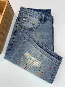 Close-up of men's vintage blue denim shorts featuring paint splatter and distressed details.