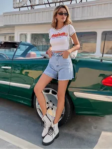 Fashionable high-waisted light blue denim shorts with raw hem shown on a model