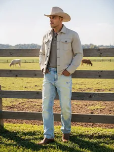 Détail de jean droit dégradé bleu clair pour homme dans un cadre de ranch en plein air.