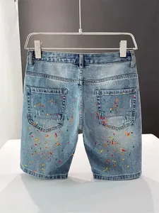Detailed back view of men's slim denim shorts with colorful paint splatter design.