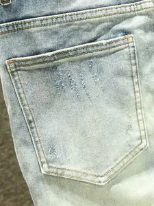 Gros plan sur la poche arrière usée d'un jean en denim extensible bleu clair dégradé
