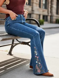 Premium women's blue denim flare jeans featuring elegant floral embroidery detailing