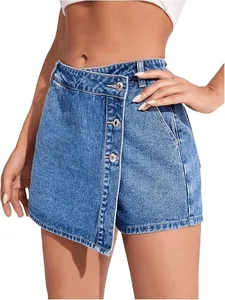 Detail van een blauwe denim skort met een asymmetrische overslag en knoopversiering aan voorkant