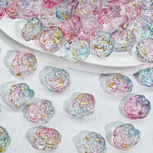 Detailed macro shot of rose-shaped gradient glass beads with gold foil for DIY jewelry