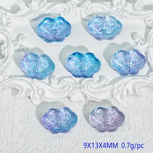 Detailed view of translucent blue and purple cloud-shaped beads with engraved patterns