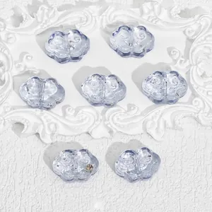 Close-up of cloud-shaped lavender glass beads with gold foil details.
