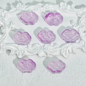 Detail view of purple cloud-shaped translucent glass beads with traditional patterns.