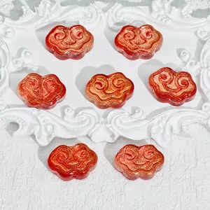 Close-up of red and gold cloud-shaped Ruyi beads with size and weight markings
