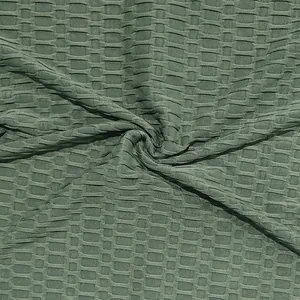 Close-up detail van olijfgroene wafelstructuurstof voor heren Henley T-shirt met spierpasvorm