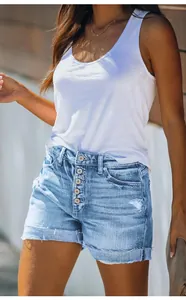 Close-up detail of women's light blue distressed denim shorts featuring a classic button fly