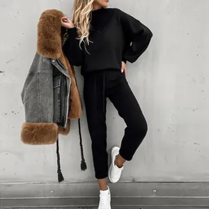 Model trägt ein schwarzes Set aus Rollkragen-Sweatshirt und Jogginghose mit Sneakern