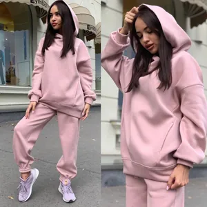 Detail view of pink oversized hoodie and matching jogger set on model in street