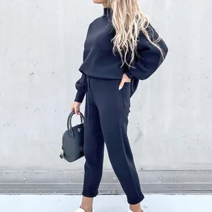 Vista laterale di una tuta nera chic a due pezzi con collo alto e pantaloni casual sportivi.