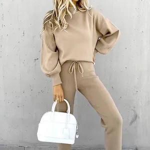 Dettaglio di un set lounge beige da donna con maglione a lupetto e pantaloni casual.