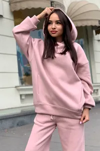 Outdoor street view of a woman wearing a pink oversized hoodie and jogger pants set