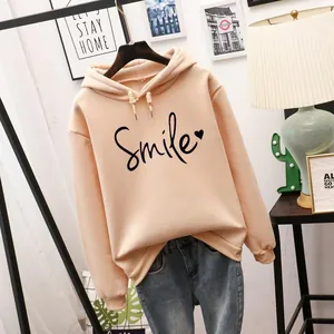 Primer plano detallado de una sudadera oversize melocotón con estampado Smile negro.