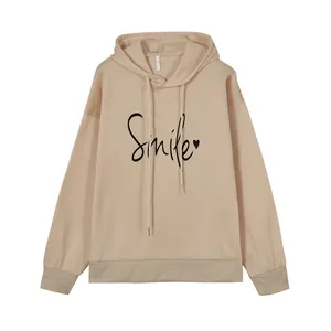 Vista detallada de la sudadera beige con capucha y estampado Smile negro con un corazón