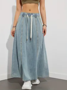 Detailed front view of a light wash denim maxi skirt featuring a drawstring elastic waist