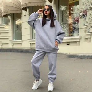Outdoor lifestyle shot of a women's grey oversized hooded sweatshirt and joggers set