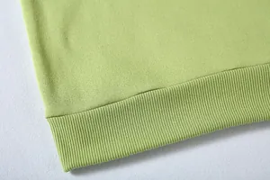 Primer plano de sudadera verde lima que muestra el dobladillo acanalado y la textura suave