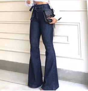 Detail shot of high-waisted dark blue flare jeans with a decorative bow-tie belt