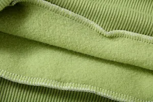 Detalle del forro polar verde suave y costuras del dobladillo acanalado de sudadera