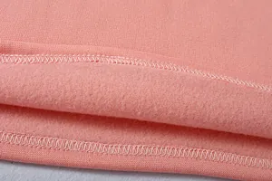 Dettaglio della morbida fodera in pile rosa e delle cuciture dell'orlo della felpa