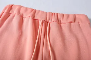 Primo piano di pantaloni della tuta rosa da donna con vita elastica e dettaglio coulisse.