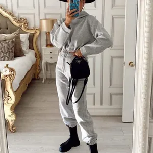Spiegelselfie einer Frau in einem grauen zweiteiligen Fleece-Trainingsanzug mit Kapuzenpullover.
