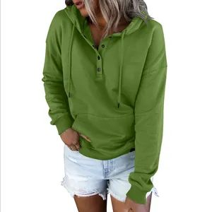 Close-up view of a casual green oversized hoodie featuring buttons and adjustable drawstrings