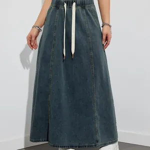 High-waisted denim maxi skirt with elastic drawstring waist and wide flared hemline.