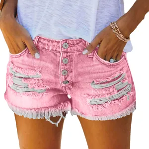 Close-up of pink distressed denim shorts with raw fringe hem and button fly for women.