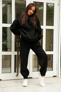 Woman wearing black solid color hooded sweatshirt and matching joggers tracksuit